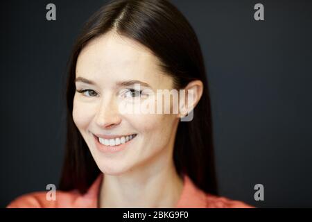 Horizontale Nahaufnahme Porträt von attraktiven jungen kaukasischen Frau Blick auf Kamera lächelnd, kopieren Raum Stockfoto