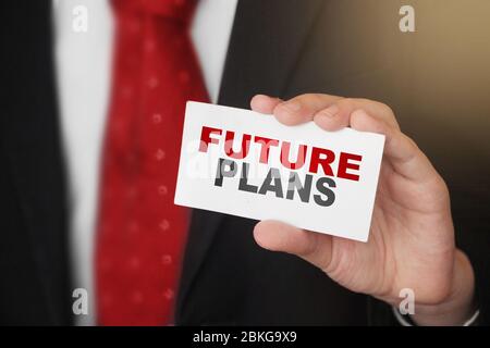 Future Plan Text Wörter auf Karte in der Hand von Geschäftsmann trägt dunkelrote Krawatte und einen Anzug. Coaching-Konzept für Geschäftsziele Stockfoto