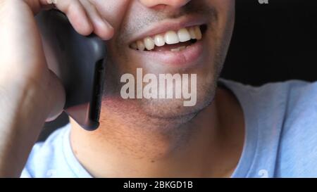 Lächeln eines Mannes, der am Telefon spricht. Stockfoto