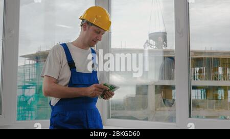 Bauarbeiter zählen das Geld. Stockfoto