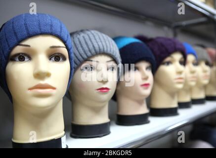 Mannequin Köpfe in gestrickten Hüte und Schals. Mannequins weibliche Köpfe in Hüten und Schals nah oben. Strickmützen und Schals aus Wolle. Weibliche Kopfbedeckung. Stockfoto