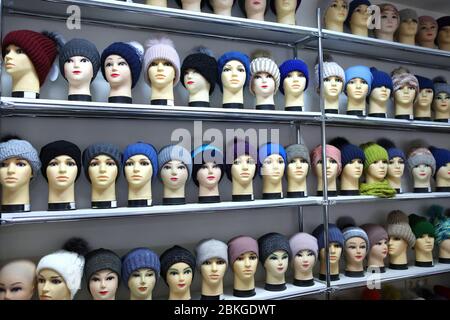 Mannequin Köpfe in gestrickten Hüte und Schals. Mannequins weibliche Köpfe in Hüten und Schals nah oben. Strickmützen und Schals aus Wolle. Weibliche Kopfbedeckung. Stockfoto