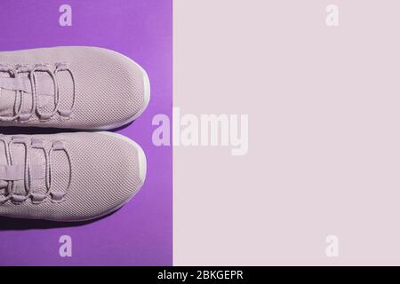 Neue lila Sneaker auf bunten Hintergrund mit Copy-Raum. Overhead-Aufnahme von Laufschuhen. Draufsicht, flaches Lay Stockfoto