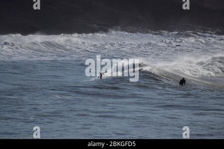 Surfer auf einer Welle in Polzeath, Cornwall, Großbritannien Stockfoto