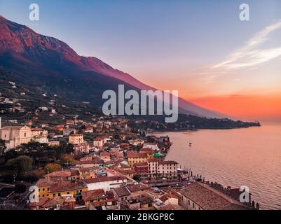 Lago Garda - Blick auf das Dorf Malcesine. Alte Burg auf dem Felsen Italien. Sonnenuntergang mit Luftbild Stockfoto