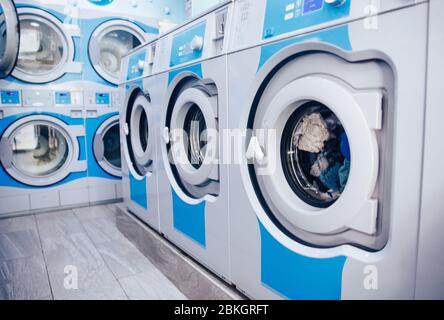 Reihe von industriellen Waschmaschinen im kommerziellen Waschsalon. Concept Business Wascherei. Stockfoto