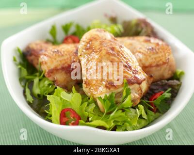 Salat mit gebratenen Hähnchenschenkeln Stockfoto