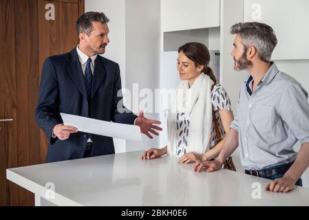 Immobilienmakler im Gespräch mit Paar Stockfoto