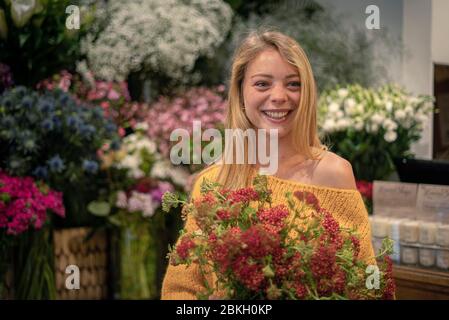 Junge Frau im Blumenladen stehend Stockfoto
