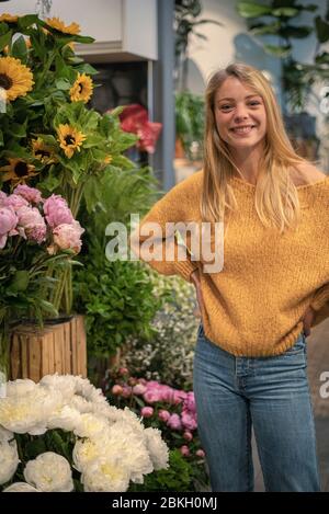 Junge Frau im Blumenladen stehend Stockfoto