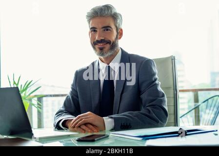 Lächelnde Geschäftsmann im Büro sitzen Stockfoto
