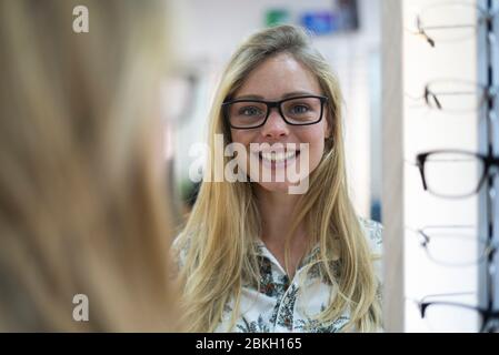 Junge Frau mit Brille im Laden Stockfoto