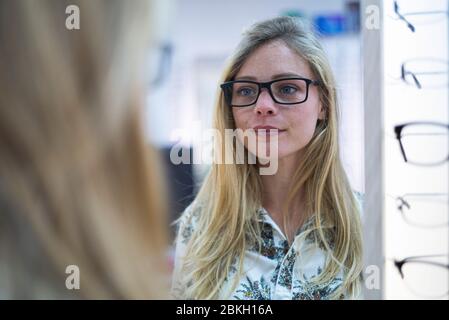 Junge Frau mit Brille im Laden Stockfoto
