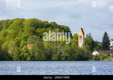 Wessling See (Weßlinger See) mit üppigen Bäumen und katholischer Kirche 'Mariae Himmelfahrt'. Schöne und ruhige Landschaft von oberbayern. Stockfoto