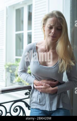 Junge Frau, die an Magenkrämpfen leidet Stockfoto