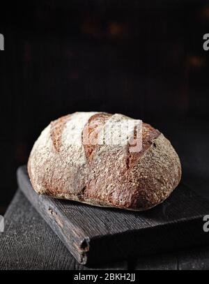 Frisch gebackenes Vollbrot auf schwarzem Holztisch Stockfoto