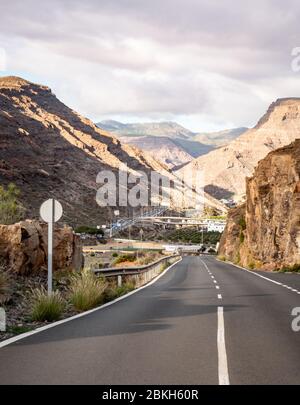 Bergpass. Eine leere Straße, die in die felsigen Berge von Gran Canaria führt, einer der größeren der Kanarischen Inseln. Stockfoto