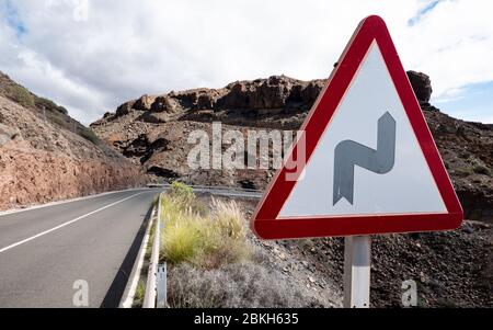 Verkehrswarnschild: Biegen Sie in Straße. Ein dreieckiges Straßenschild, das eine Kurve voraus in der Autobahn anmeldet. Stockfoto