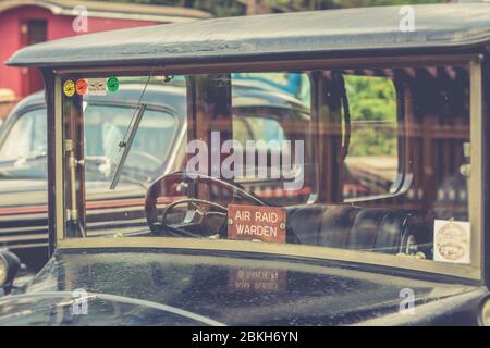 Retro Nahaufnahme von Oldtimer im Freien geparkt Severn Valley Railway 1940s Kriegszeit WWII Sommer Ereignis. 1940er Jahre, Auto des 2. Weltkriegs mit Luftangriffswartschild. Stockfoto