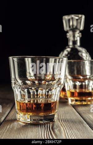 Whiskey Glas und Flasche auf dem alten Holztisch Stockfoto