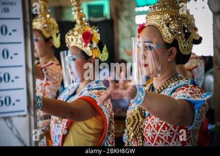 Bangkok, Thailand. Mai 2020. Thailändische Tänzerinnen tragen traditionelle Kleidung und Gesichtsschilde, um sich vor dem Coronavirus (Covid-19) zu schützen, der im Erawan Shrine in Ratchaprasong Junction tanzt. Quelle: SOPA Images Limited/Alamy Live News Stockfoto