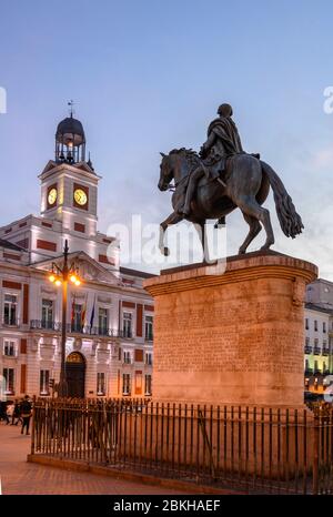 Die Puerta del Sol bei Nacht mit der Statue von Carlos III und der Real Casa de Correos im Hintergrund, im Zentrum von Madrid, Spanien. Stockfoto