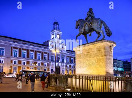 Die Puerta del Sol bei Nacht mit der Statue von Carlos III und der Real Casa de Correos im Hintergrund, im Zentrum von Madrid, Spanien. Stockfoto