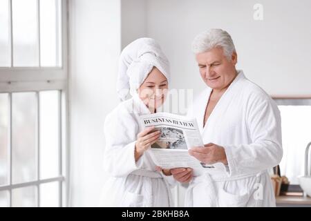 Ältere Paare lesen Zeitung im Badezimmer Stockfoto