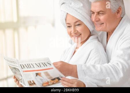 Ältere Paare lesen Zeitung im Badezimmer Stockfoto