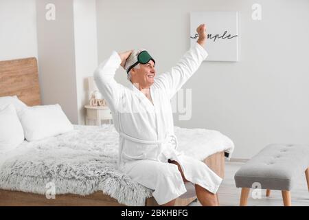 Morgen des glücklichen reifen Mannes im Schlafzimmer Stockfoto