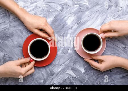 Weibliche Hände mit Tassen Kaffee auf grunge Hintergrund Stockfoto