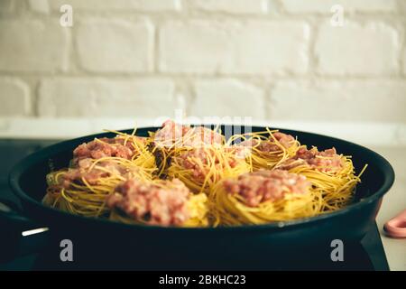 Nest von Spaghetti mit Fleischbällchen und Tomatensauce vor dem Kochen Stockfoto