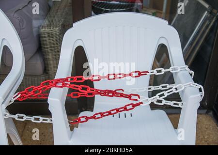 Weiße Plastikstühle mit Kette im Sommer Café in der Nähe des Shops. Stockfoto