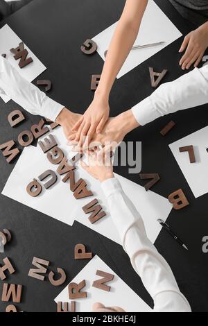 Team von Geschäftsleuten, die im Büro die Hände zusammenlegen, Draufsicht Stockfoto
