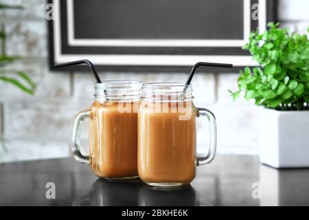 Mason Gläser mit leckeren Eiskaffee auf dem Tisch im Café Stockfoto