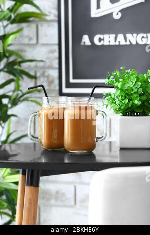 Mason Gläser mit leckeren Eiskaffee auf dem Tisch im Café Stockfoto