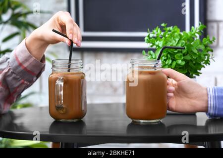 Frauen mit Maurer Gläser von leckeren Eiskaffee im Café, Nahaufnahme Stockfoto