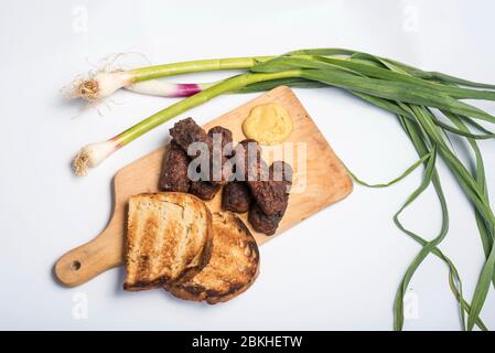 Mici Cu bere traditionelle rumänische Gericht für die Feierlichkeiten der 1. Mai der Tag der Arbeit. Treffen Bälle Fleisch Brötchen Gericht und Bier türkischen Kofte Stockfoto