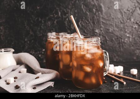 Mason Gläser von leckeren Eiskaffee auf dunklem Hintergrund Stockfoto