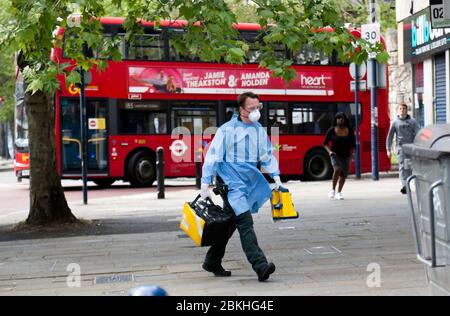 London Ambulance Crewmember, gekleidet in persönliche Schutzausrüstung, kommt in Lewisham Hight Street an, um während der COVID-19 Pandemie an einem medizinischen Notfall teilzunehmen Stockfoto