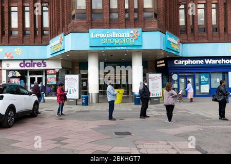 Kunden, die strenge soziale Distanzierung beobachten, müssen während der COVID-19 Pandemie geduldig in die NatWest Bank in der Lewisham Hight Street eintreten Stockfoto