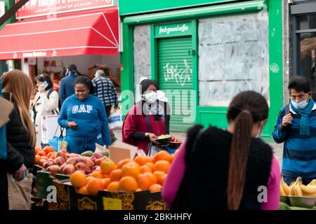 Menschen kaufen während des COVID-19-Ausbruchs auf dem Lewisham Market Lebensmittel ein, setzen soziale Distanzierungsmaßnahmen ein und tragen und stellen Masken auf. Stockfoto