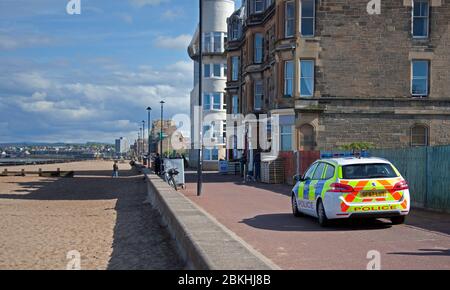 Portobello, Edinburgh, Schottland, Großbritannien, 5. Mai 2020. Sonnige aber kühle Brise Temperatur um 14 Grad Celsius an einer meist ruhigen Promenade und Strand mit zwei Patrouillen von Polizeifahrzeugen in der Zeit von zehn Minuten. Radfahrer scheinen immer noch über Flecken des Laufs zu übernehmen, was es für Fußgänger schwierig macht, immer ihren sozialen Abstand zu anderen zu halten. Einige extreme Hundeübungen am Sandstrand von ein paar Hundebesitzern und ihren Haustieren. Quelle: Arch White/Alamy Live News Stockfoto