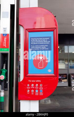 Sicherheitshinweis, in dem Personen aufgefordert werden, sich bei der Verwendung von Benzinpumpen in einer Tesco Esso Express Tankstelle in Loampit Vale, Lewisham, nicht mit Covid-19 zu verunreinigen Stockfoto