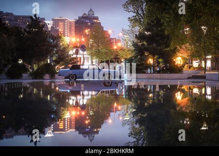 Odessa, Ukraine - April 03 2020: Blick auf moderne Nacht Stadt und Retro-Auto in Odessa von Arсadia, mit Reflexion auf der Wasseroberfläche. Konzept: Nachtleben, R Stockfoto