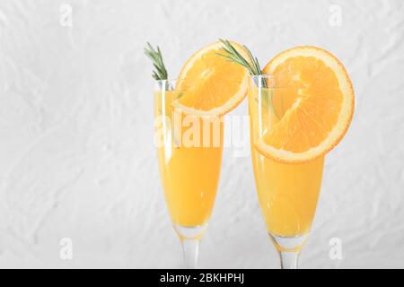 Gläser mit leckeren Mimosa-Cocktails auf hellem Hintergrund Stockfoto