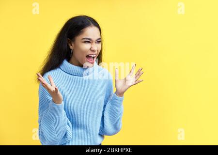 Schreiende emotionale wütend schwarze Frau auf gelbem Hintergrund. Negative Emotionen, Hass, Wut oder Stress Konzept Stockfoto