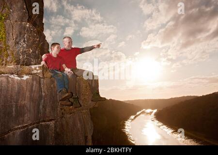 Vater und Sohn sitzen auf einer Kante Stockfoto