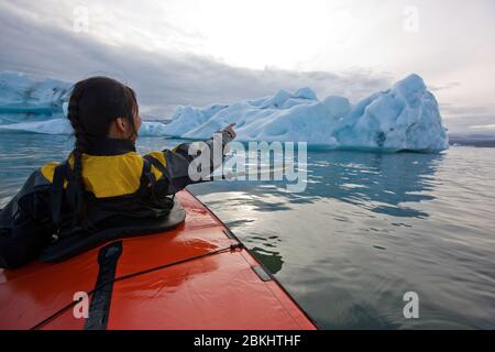 Frau rudert Seekajak auf JÃ¶kulsÃ¡rlÃ³n Gletscherlagune in Island Stockfoto