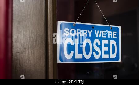 Nahaufnahme eines geschlossenen Schildes, das im Schaufenster eines Ladens hängt. Stockfoto
